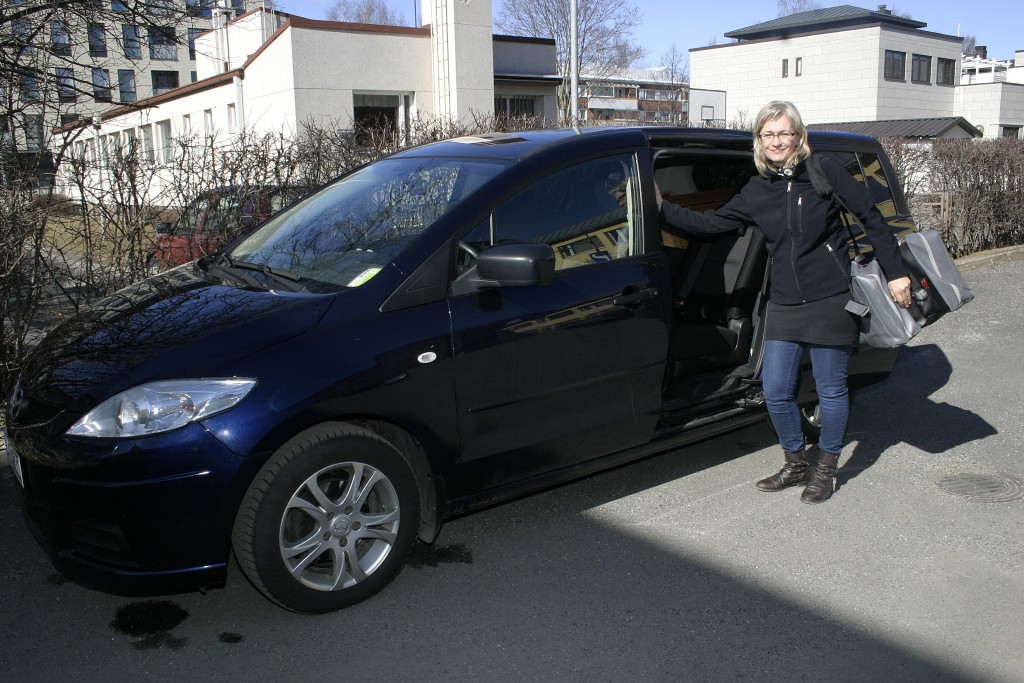 Pianonvirittäjä Päivi Heinilä auton vieressä.